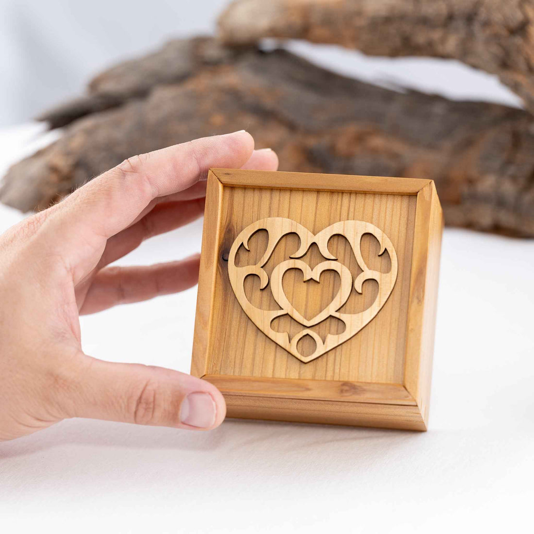 A handmade cedar wood box with a heart design from the Legend of Zelda on the lid. The box is held in a hand on a white background. Made by Min Turn Makers.