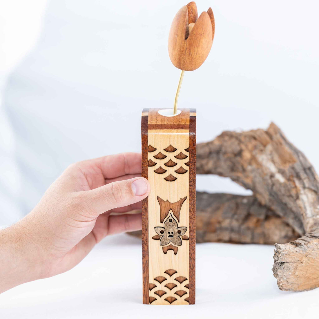 A handmade wooden vase featuring a Korok from the Zelda series of videogames.