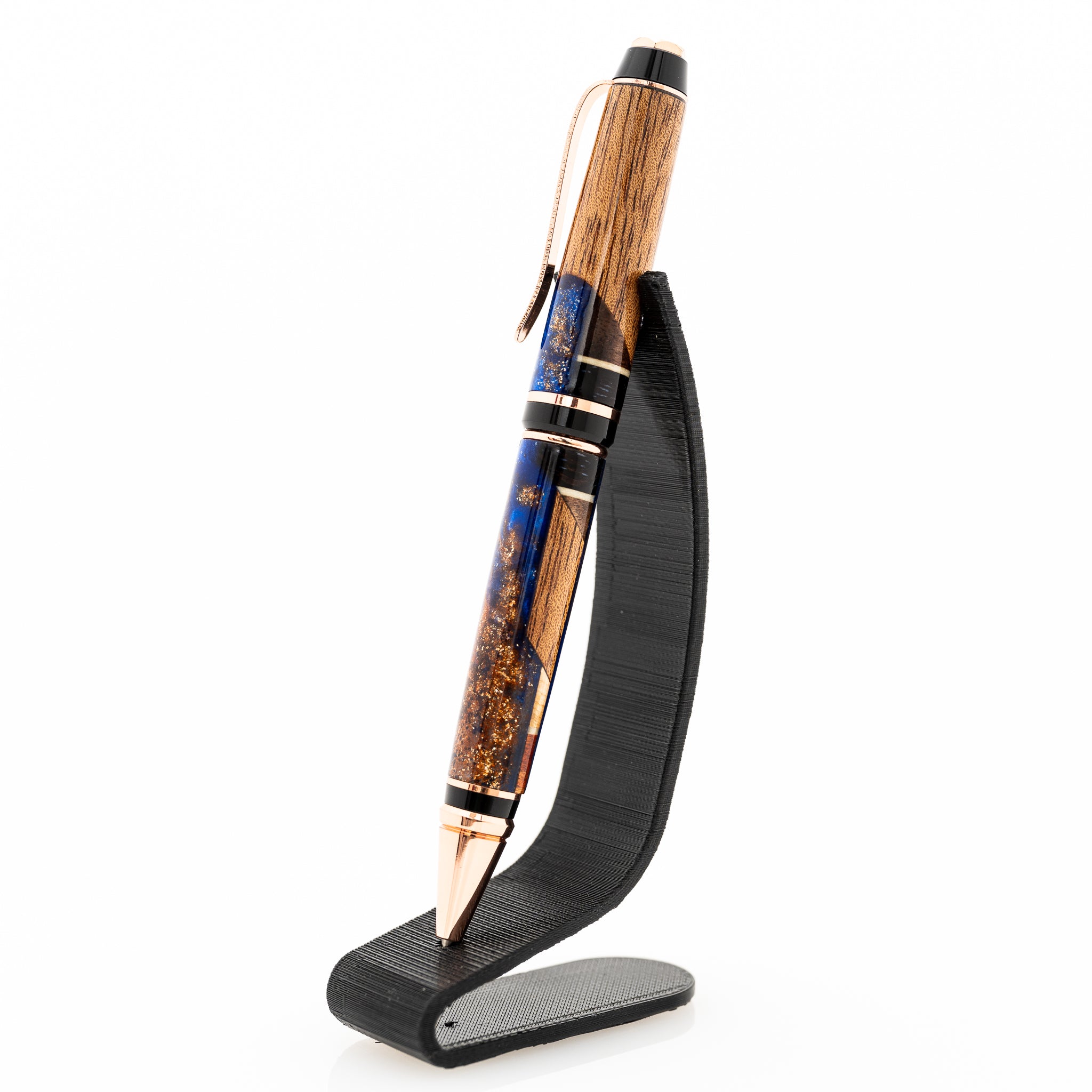 a handmade african mahogany and walnut wood and blue resin twist pen on a black stand