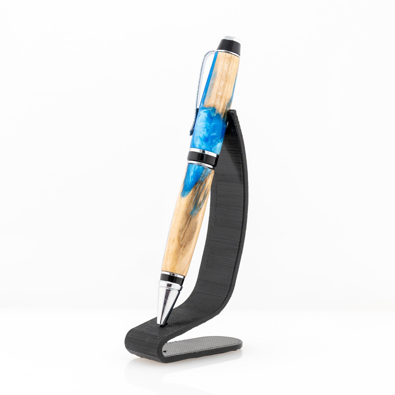 A handmade maple wood and blue resin twist cigar pen on a stand