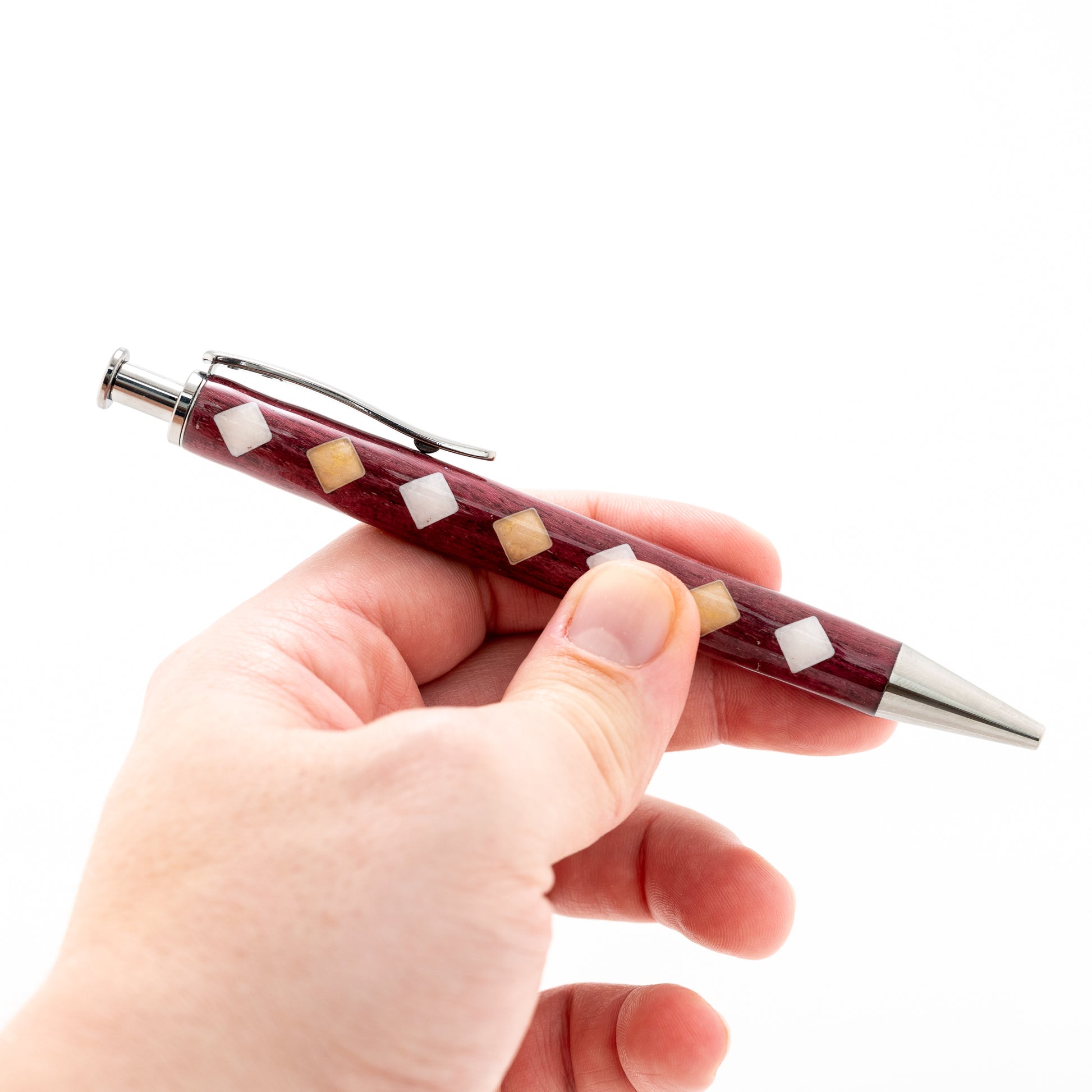 Handmade purpleheart wood click pen with seven alternating colored resin filled diamonds