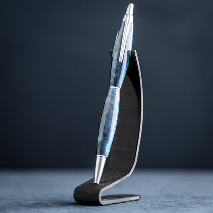 Blue and silver pen on a black stand against a dark background