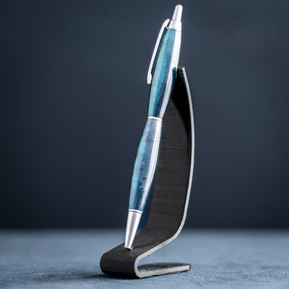 Blue pen with silver accents on a black stand against a dark background