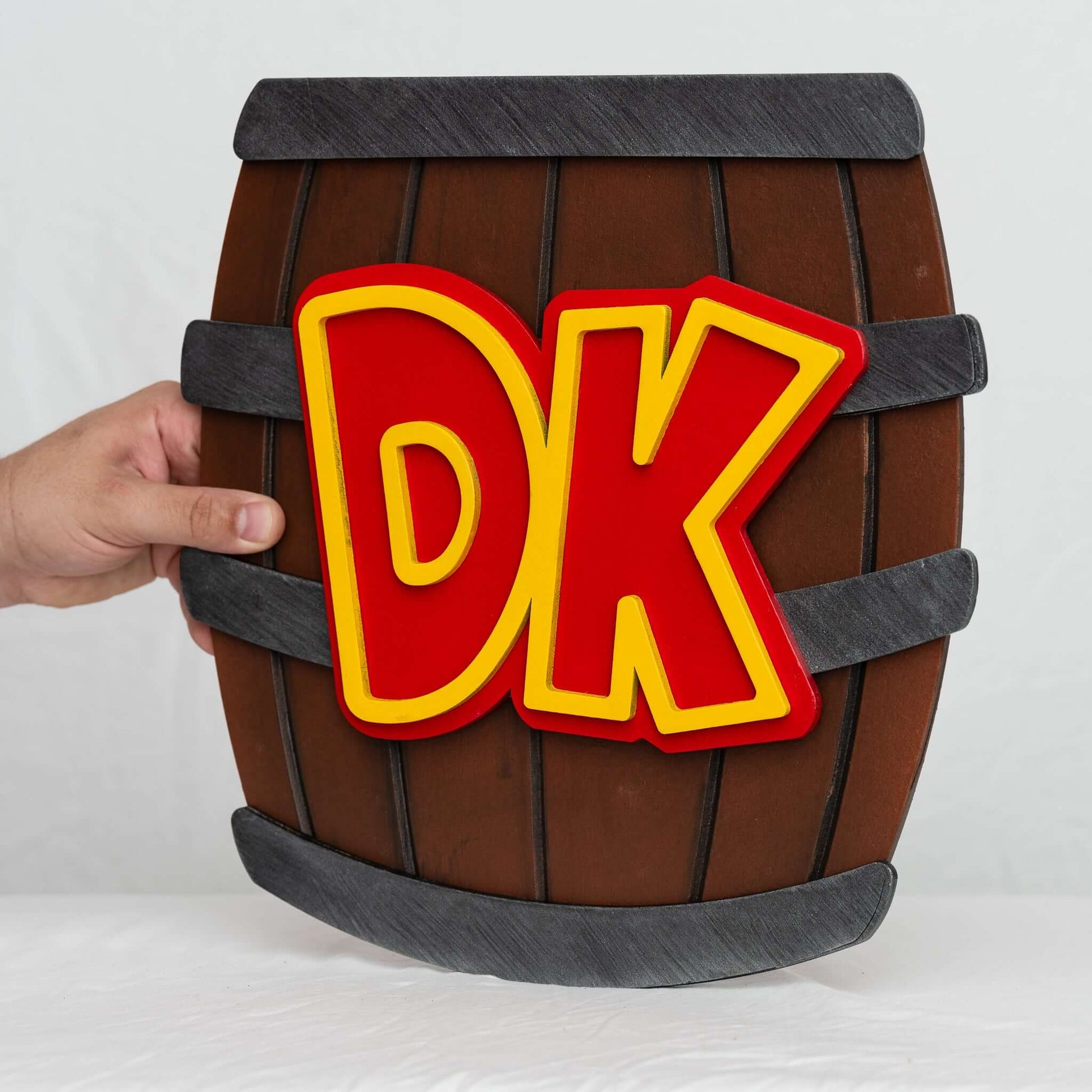 A handmade and hand-painted carved wooden sign featuring the barrel from the Donkey Kong series of Nintendo video games.