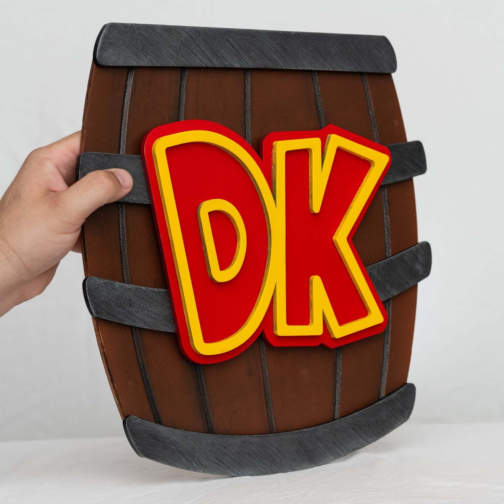 A handmade and hand-painted carved wooden sign featuring the barrel from the Donkey Kong series of Nintendo video games.