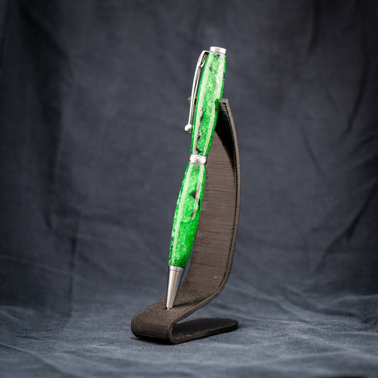 A handmade green resin ballpoint twist pen with black ink and black and silver swirls.