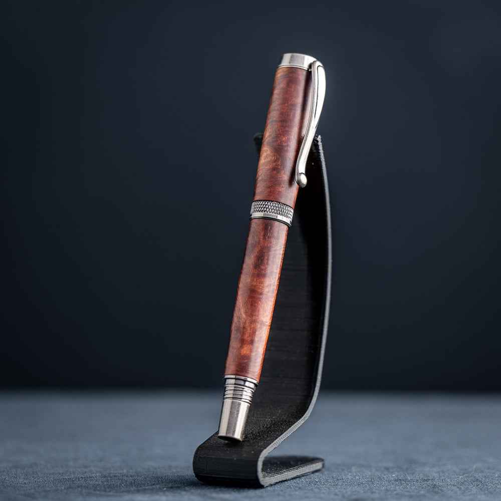 Handcrafted Australian Mallee Burl wood rollerball pen on a dark stand against a dark background.
