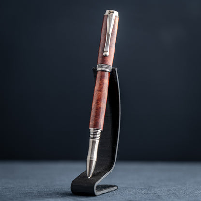 Handcrafted Australian Mallee Burl wood rollerball pen on a dark stand against a dark background.