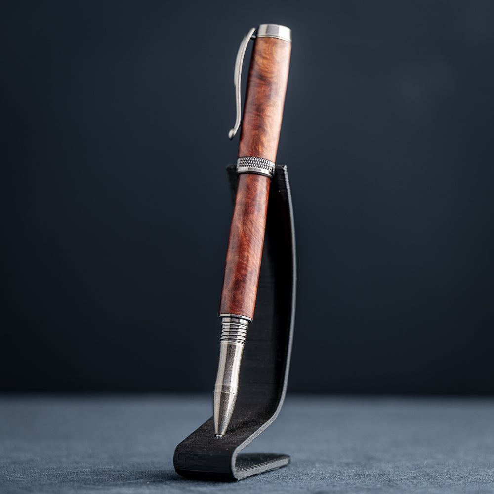 Handcrafted Australian Mallee Burl wood rollerball pen on a dark stand against a dark background.