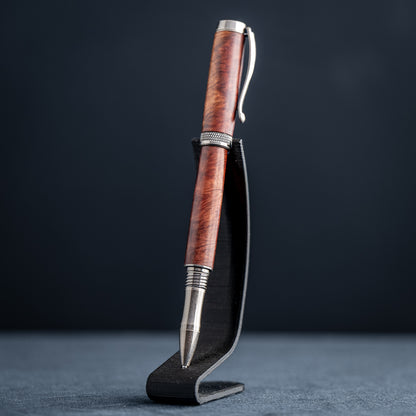Handcrafted Australian Mallee Burl wood rollerball pen on a dark stand against a dark background.
