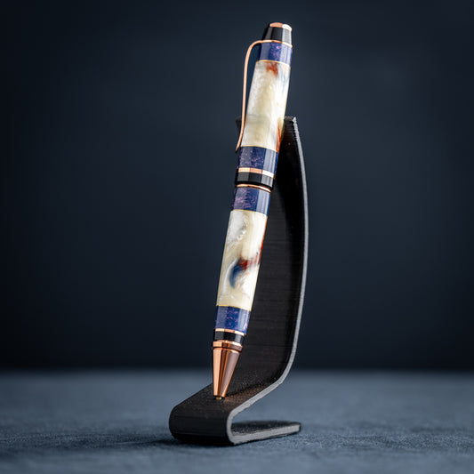 Handmade opal and purple resin ballpoint twist pen with copper plating on dark stand against a dark background.