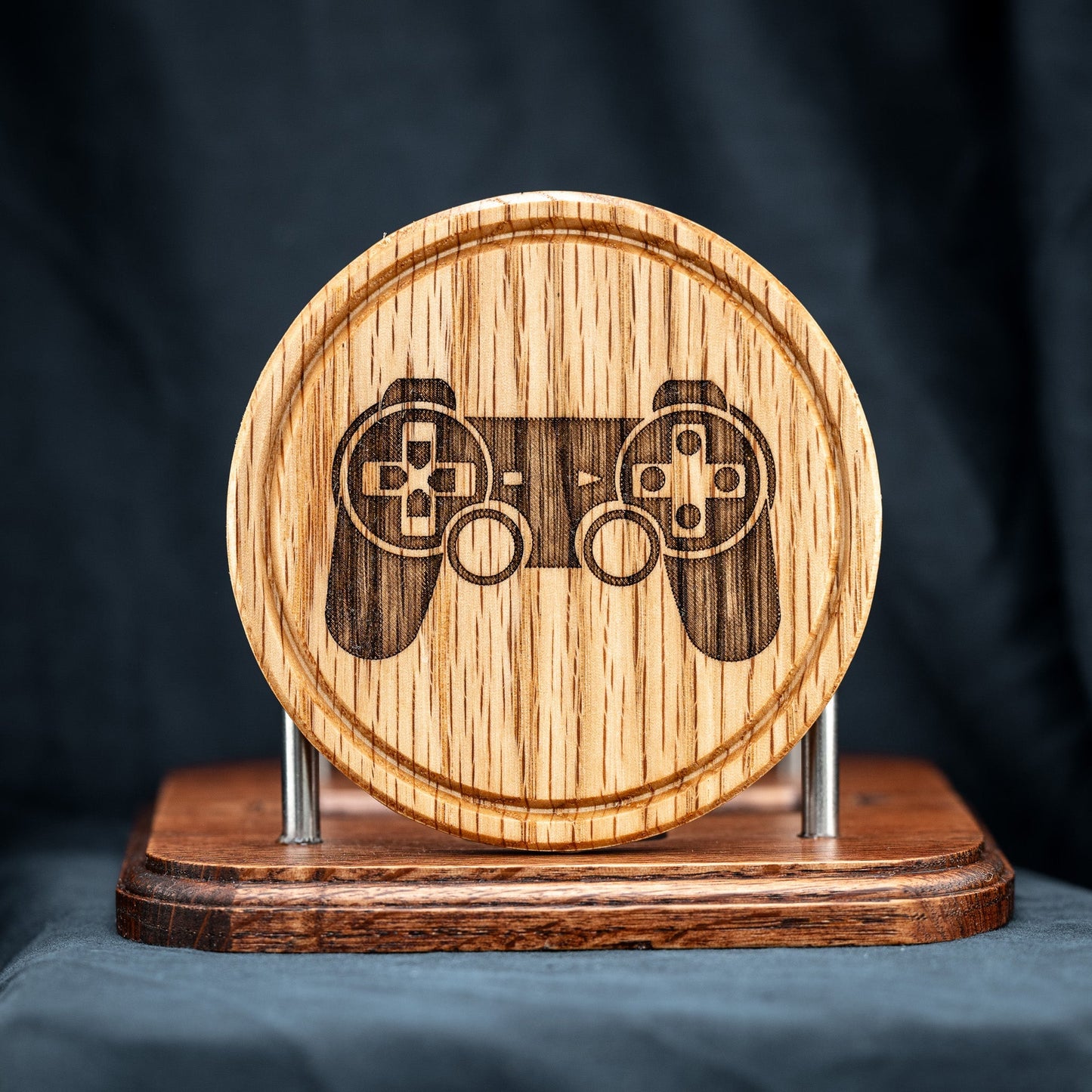 A handmade Red Oak wood drink coaster with Playstation video game controller design.