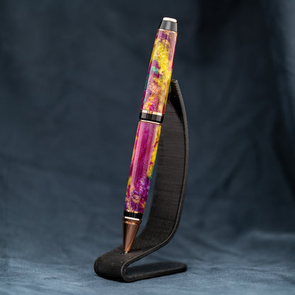 Handmade purple, green, and yellow resin twist ballpoint pen with bright copper plating and black ink.