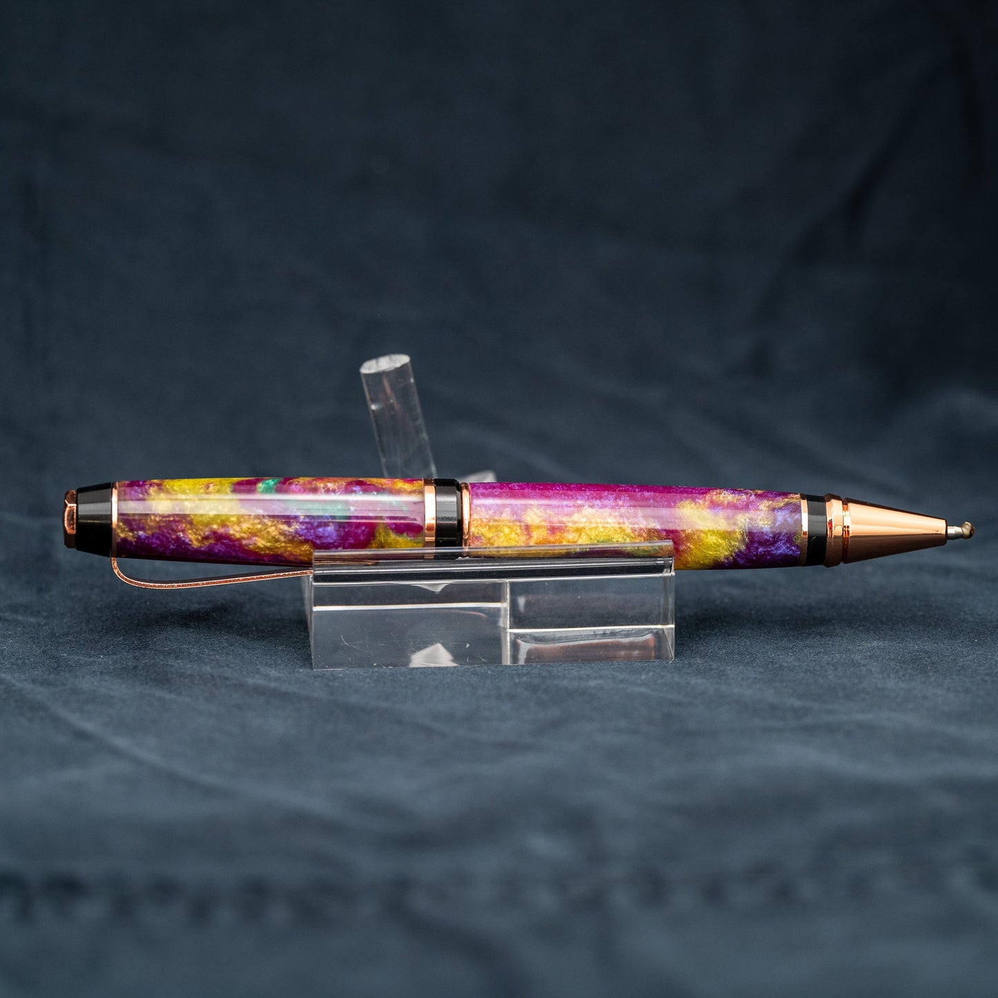 Handmade purple, green, and yellow resin twist ballpoint pen with bright copper plating and black ink.