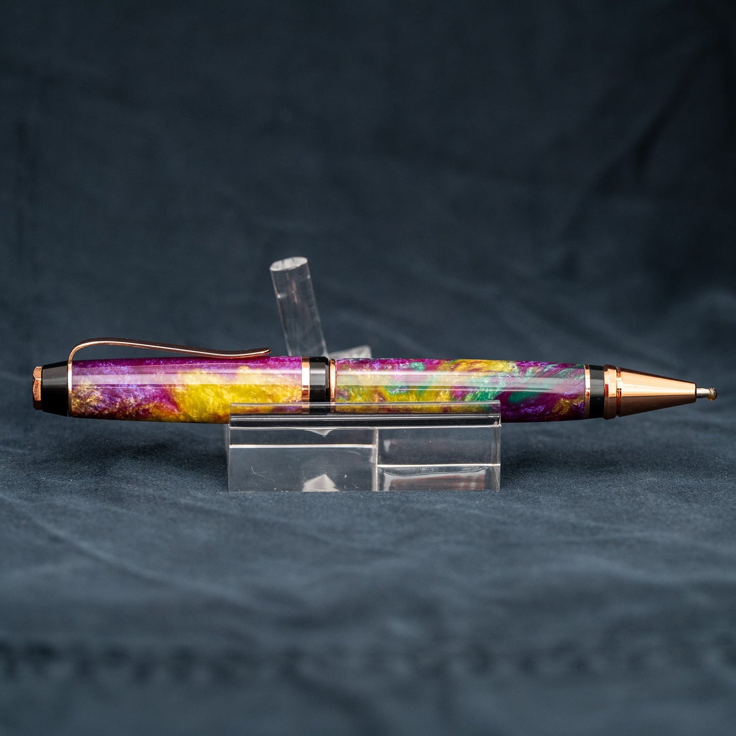 Handmade purple, green, and yellow resin twist ballpoint pen with bright copper plating and black ink.