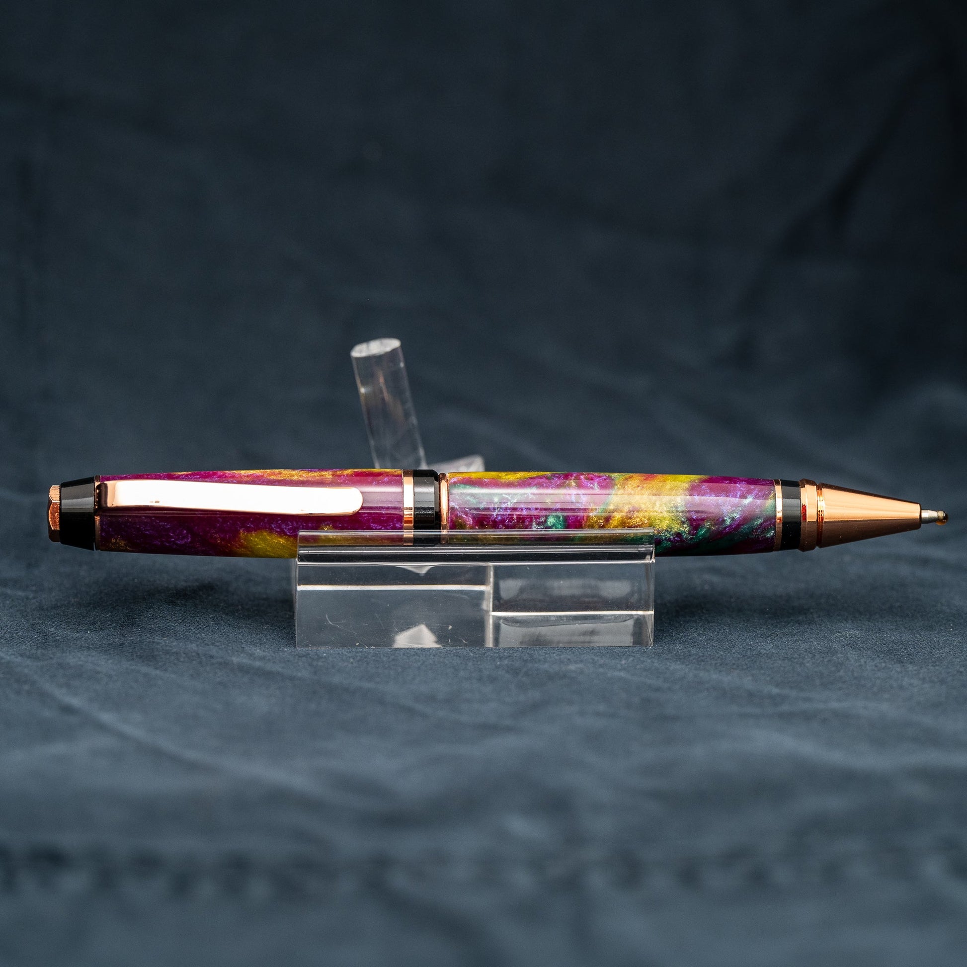 Handmade purple, green, and yellow resin twist ballpoint pen with bright copper plating and black ink.