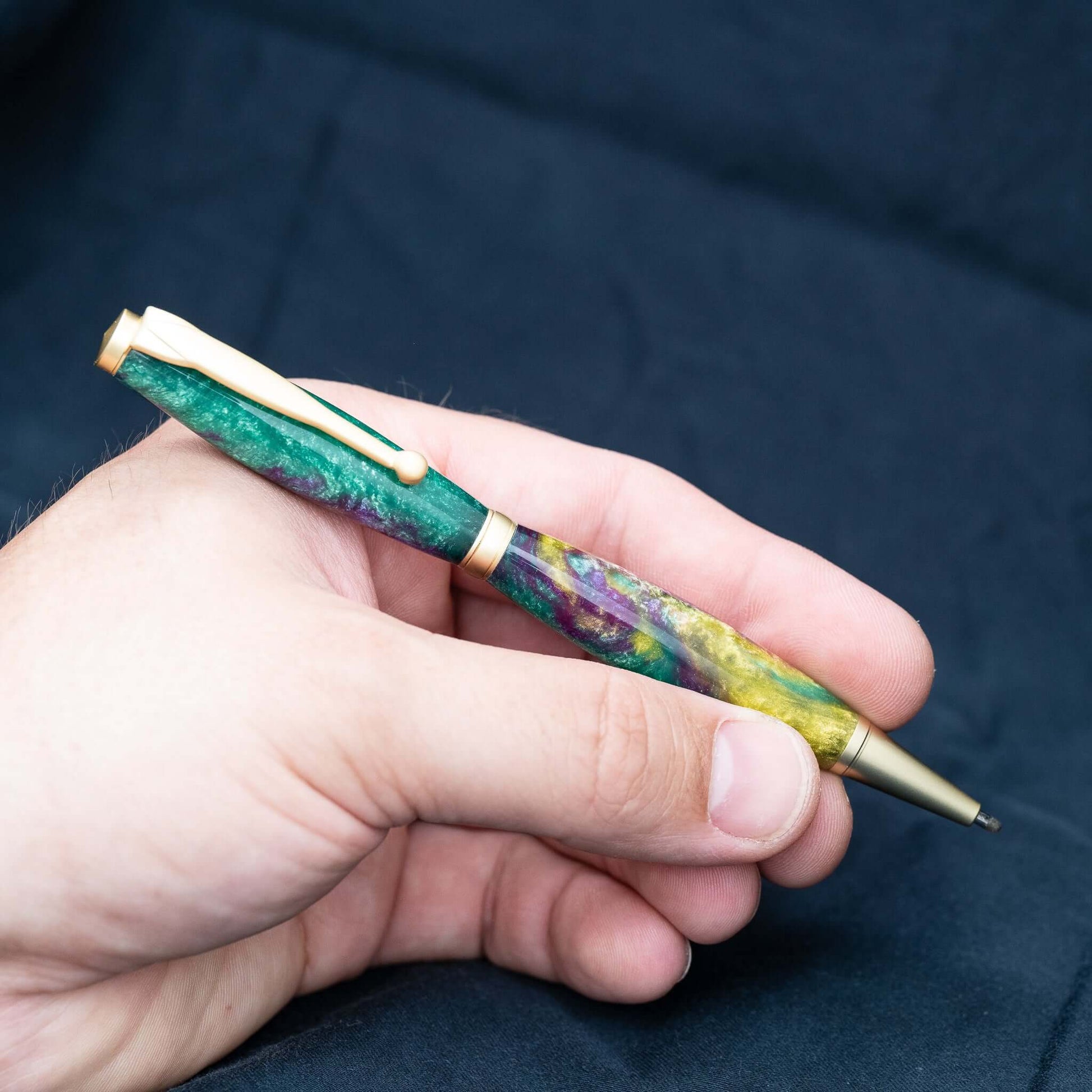 A handmade green, yellow, and purple resin ballpoint slimline twist pen with satin gold plating.