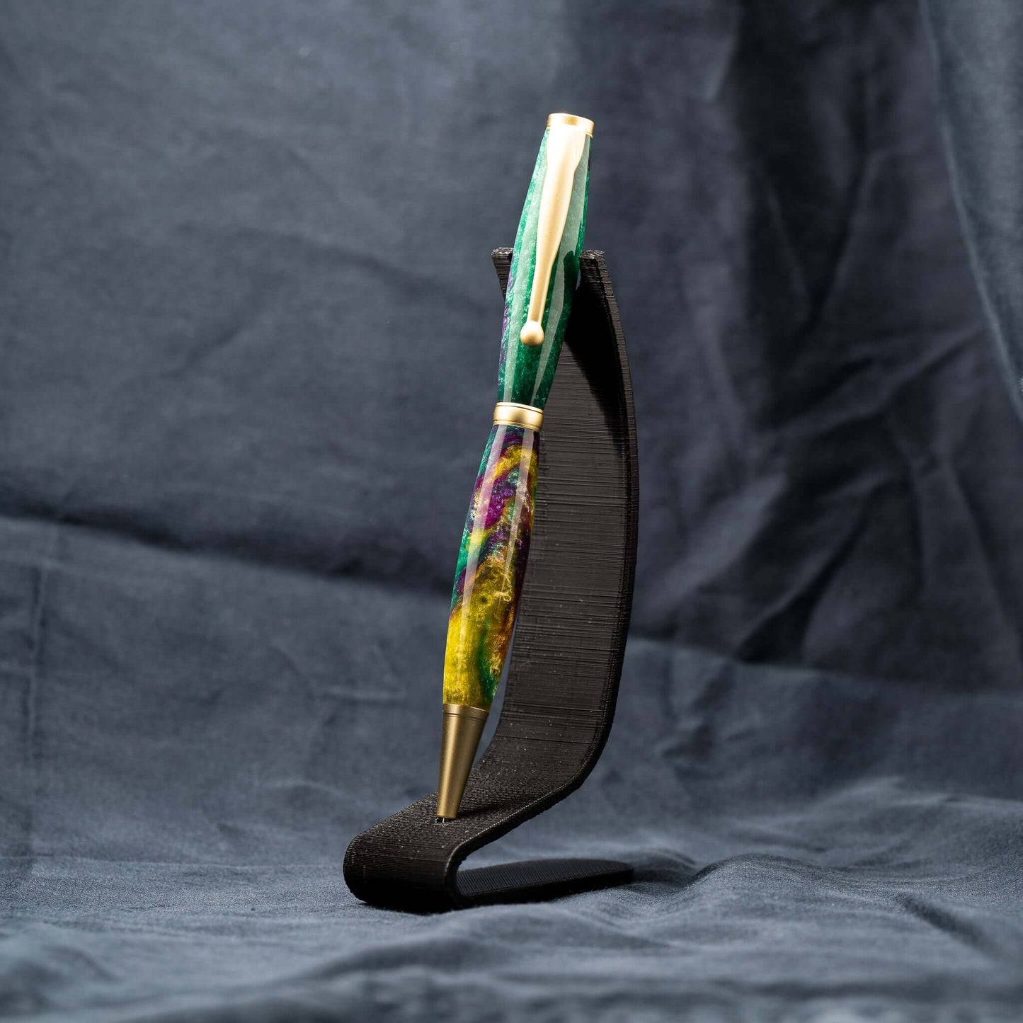 A handmade green, yellow, and purple resin ballpoint slimline twist pen with satin gold plating.