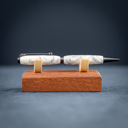 Pen with marble design on a wooden stand against a dark background