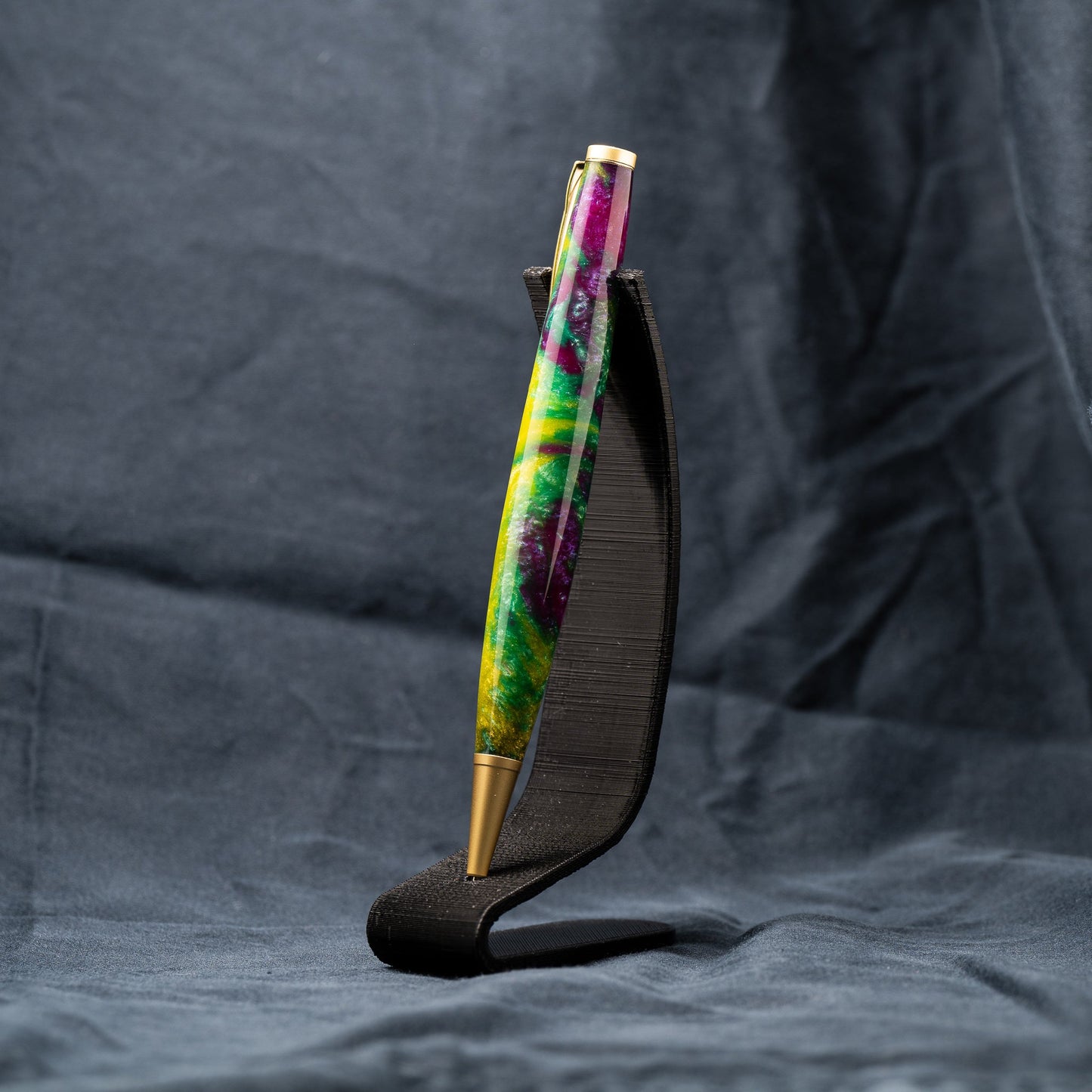 A handmade green, yellow, and purple resin ballpoint slimline twist pen with satin gold plating.