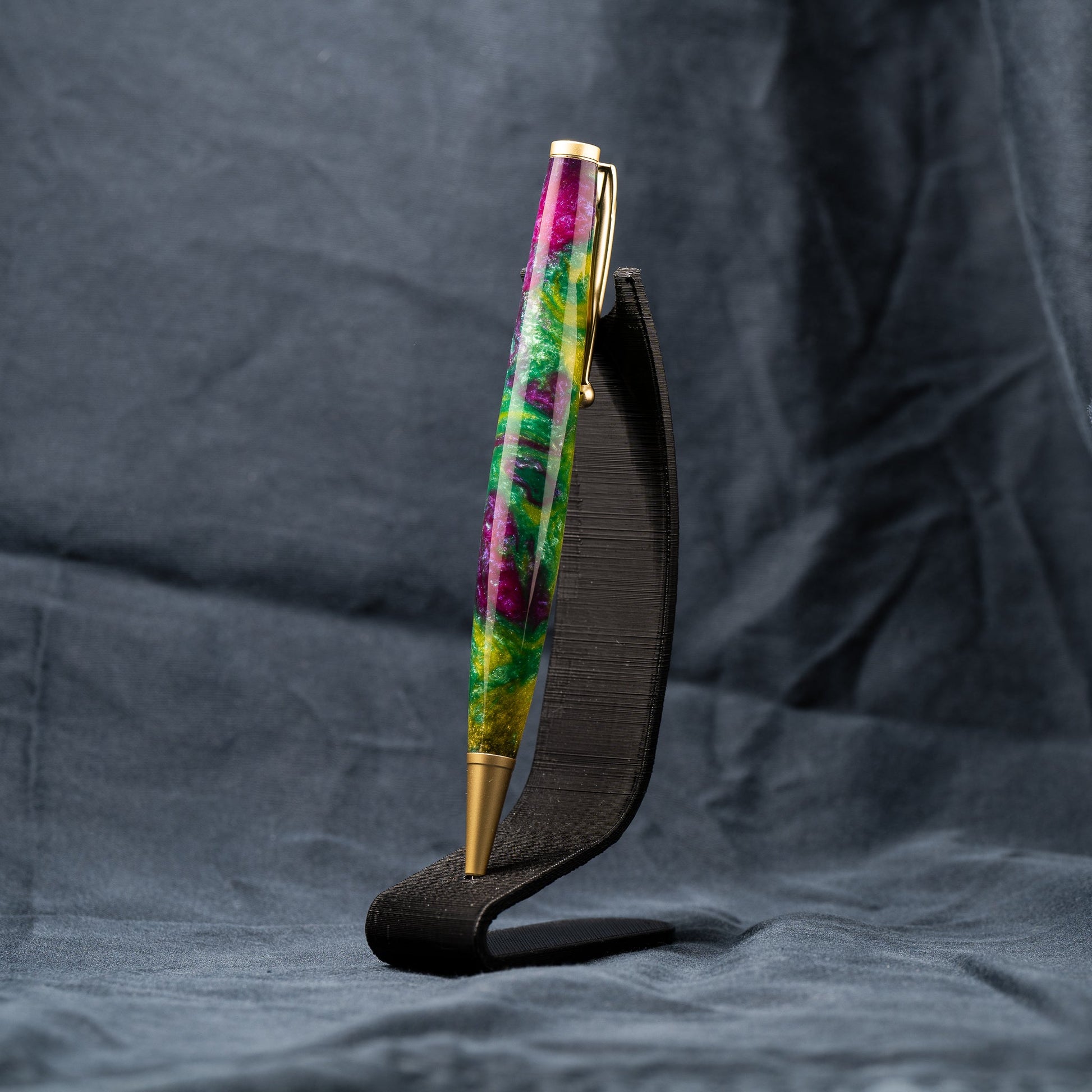 A handmade green, yellow, and purple resin ballpoint slimline twist pen with satin gold plating.