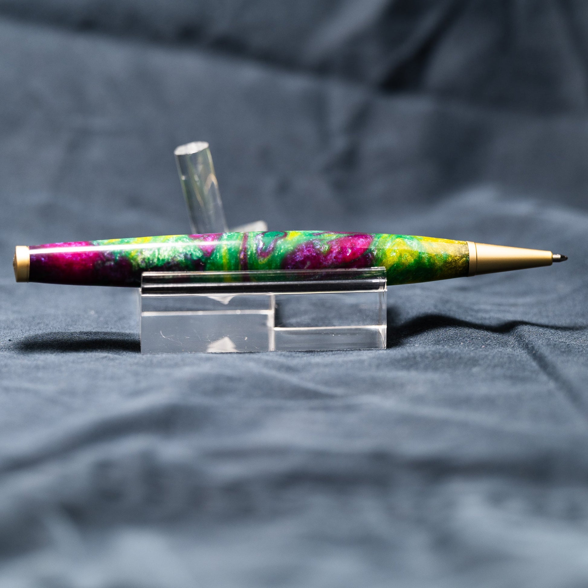 A handmade green, yellow, and purple resin ballpoint slimline twist pen with satin gold plating.