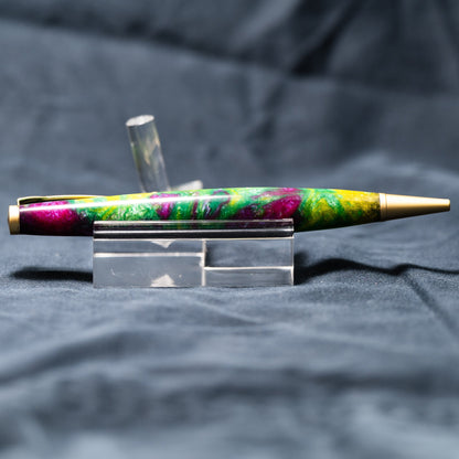 A handmade green, yellow, and purple resin ballpoint slimline twist pen with satin gold plating.