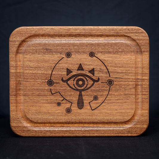 A handmade African Mahogany wooden cutting board featuring the Sheikah eye from the Legend of Zelda video games in resin inlay.