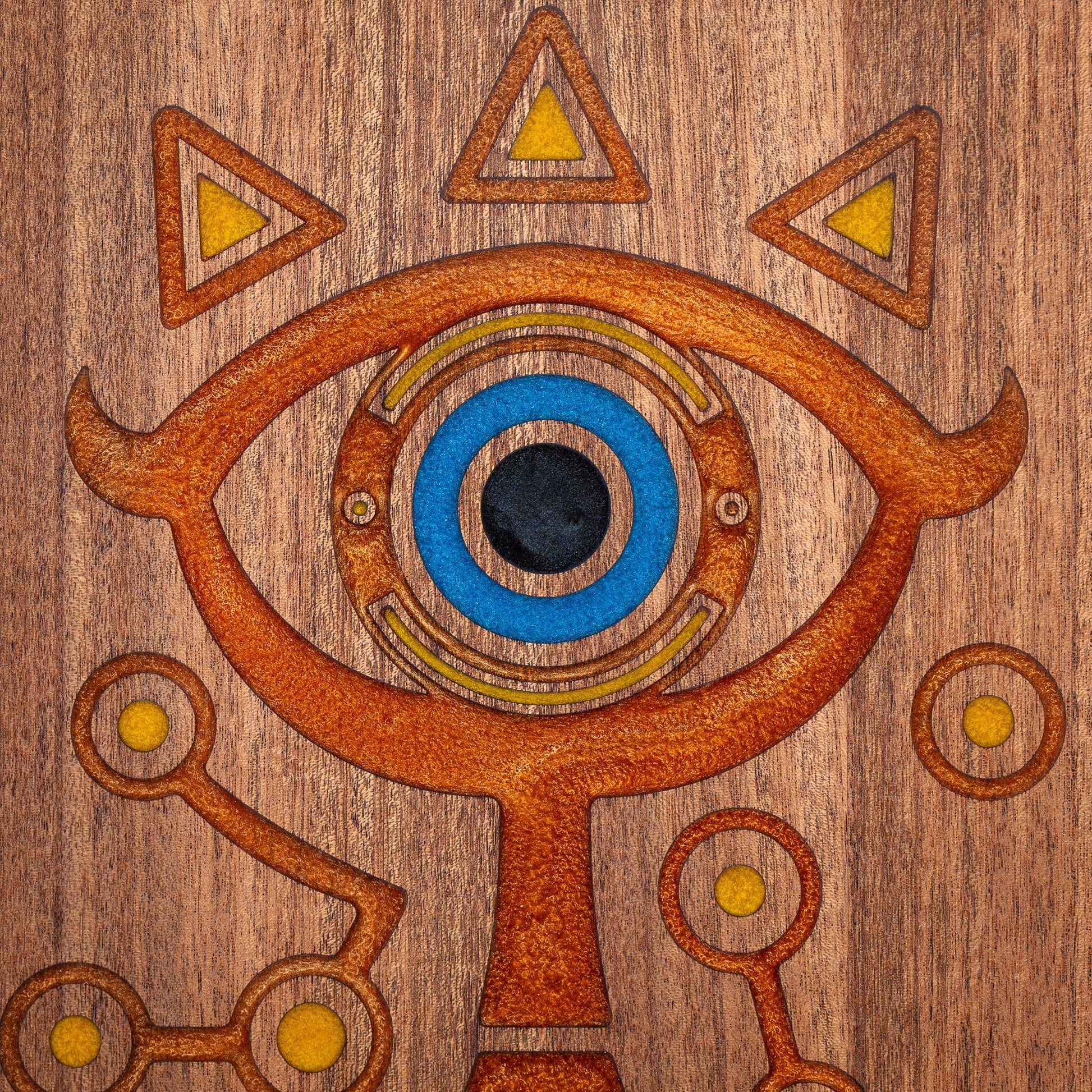 A handmade African Mahogany wooden cutting board featuring the Sheikah eye from the Legend of Zelda video games in resin inlay.