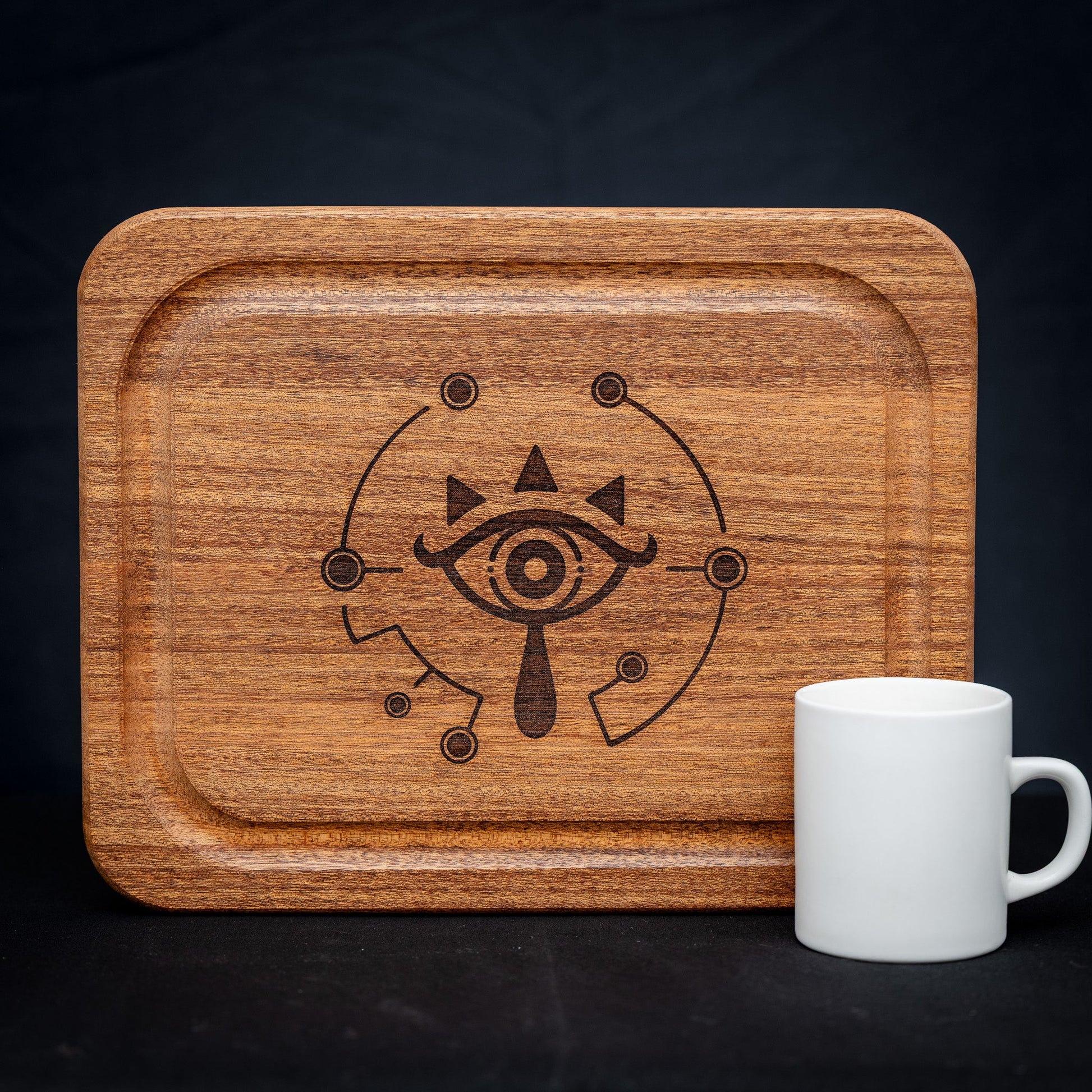 A handmade African Mahogany wooden cutting board featuring the Sheikah eye from the Legend of Zelda video games in resin inlay.