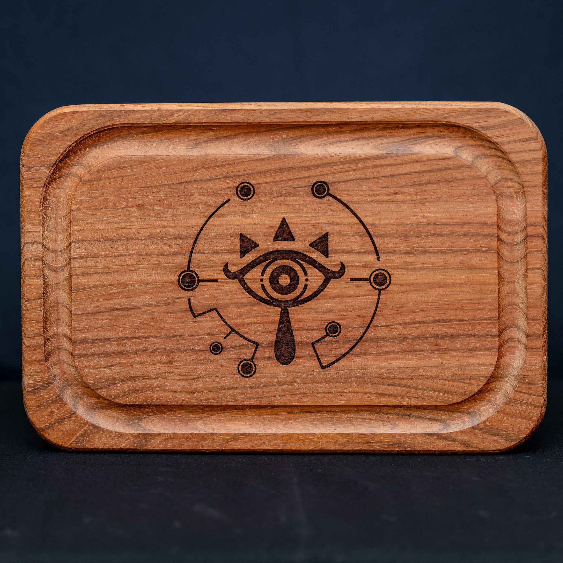 A handmade Jatoba wooden cutting board featuring the Sheikah eye from the Legend of Zelda video games in resin inlay.