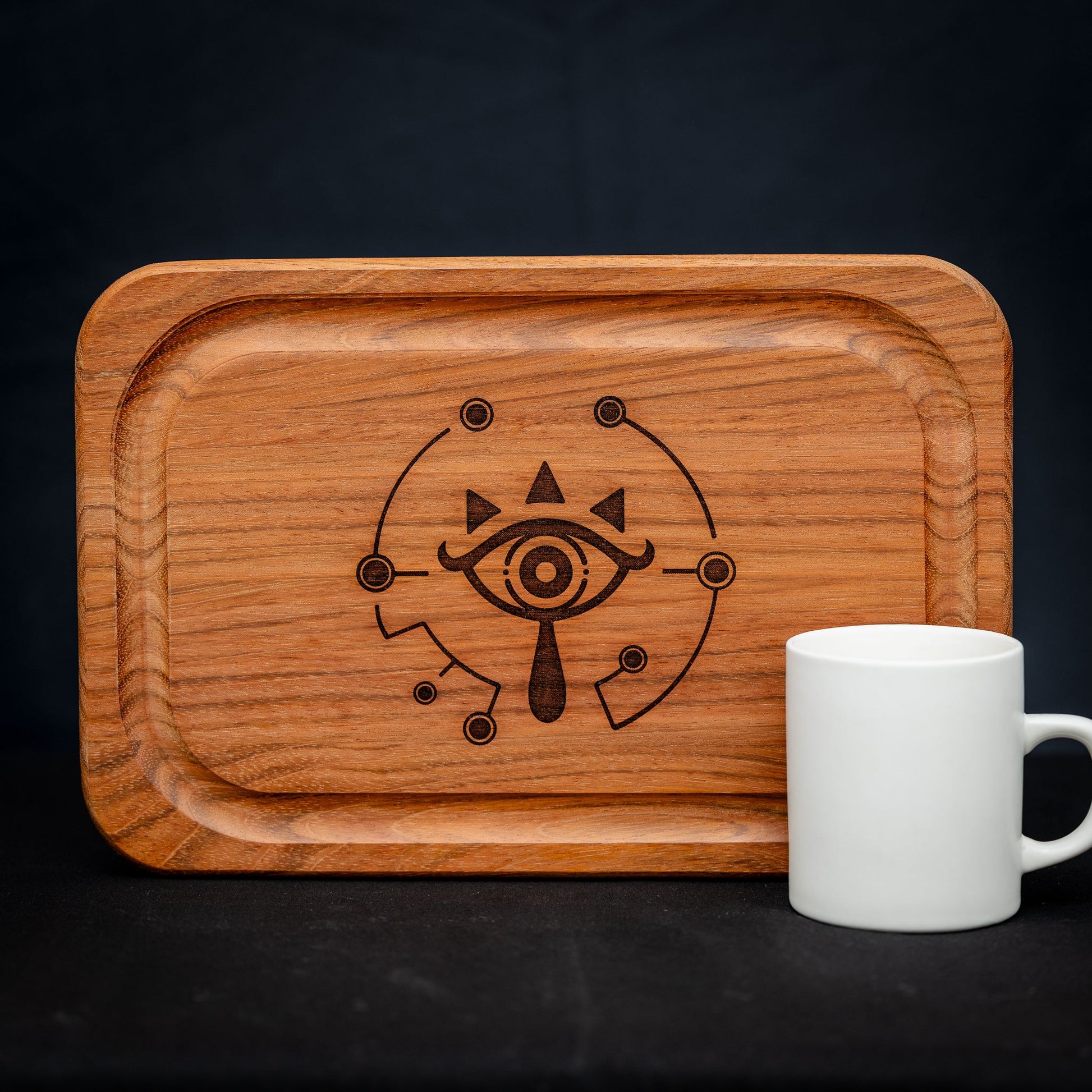 A handmade Jatoba wooden cutting board featuring the Sheikah eye from the Legend of Zelda video games in resin inlay.