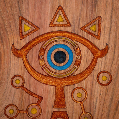 A handmade Jatoba wooden cutting board featuring the Sheikah eye from the Legend of Zelda video games in resin inlay.