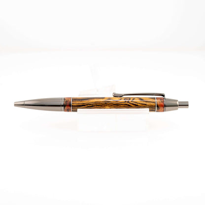 Handmade Bocote wood click pen with red resin ends separated by polished aluminum bands and gunmetal plating
