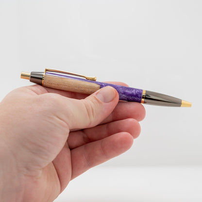 Handmade click pen with Maple wood surrounded by purple sparkle resin with gold and gunmetal plating