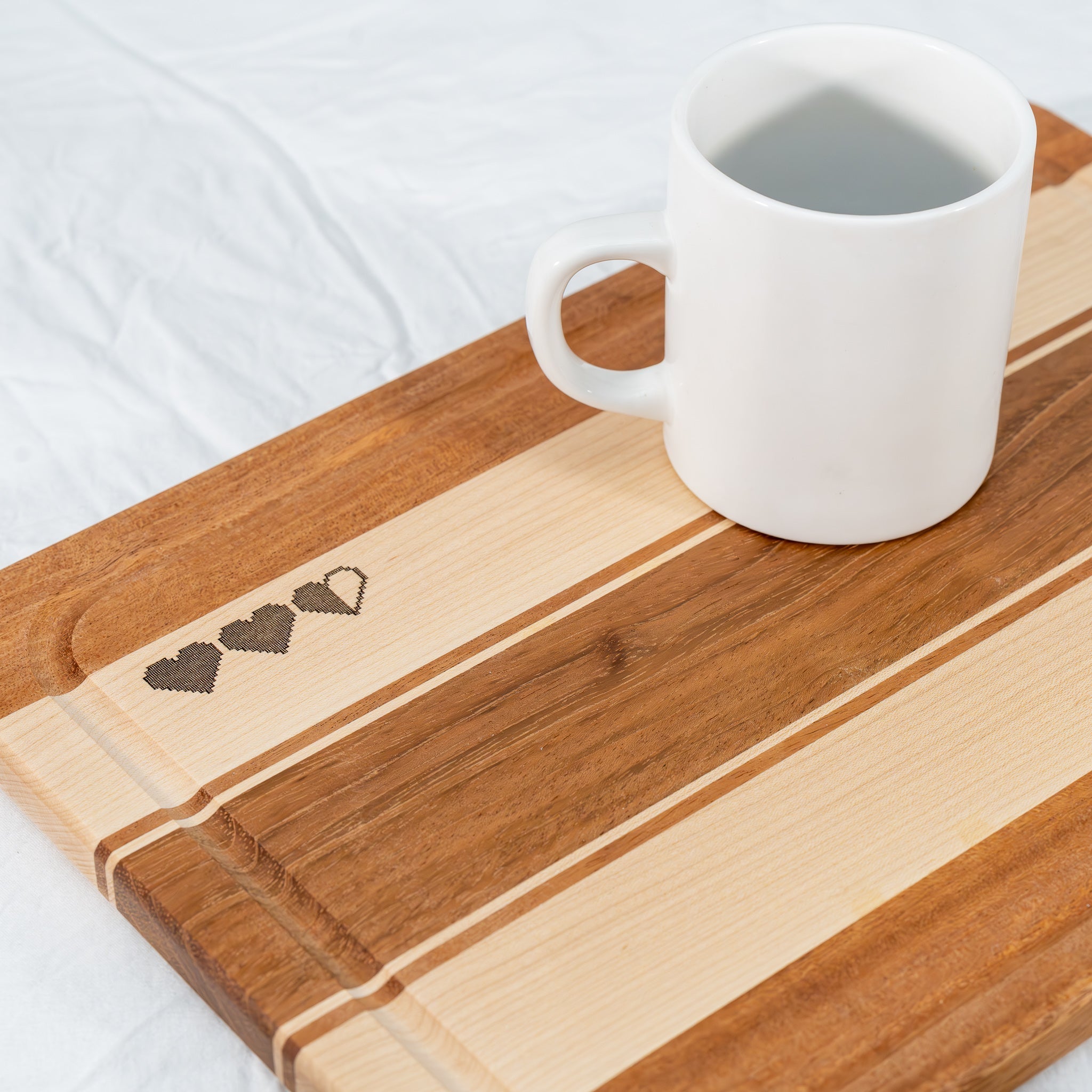 Handmade Hard Maple and Jatoba cutting board with Zelda-themed laser engraved hearts and mug