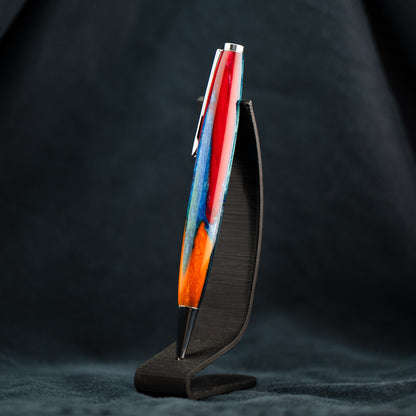 A handmade red, blue, orange, and green resin ballpoint twist pen with chrome plating