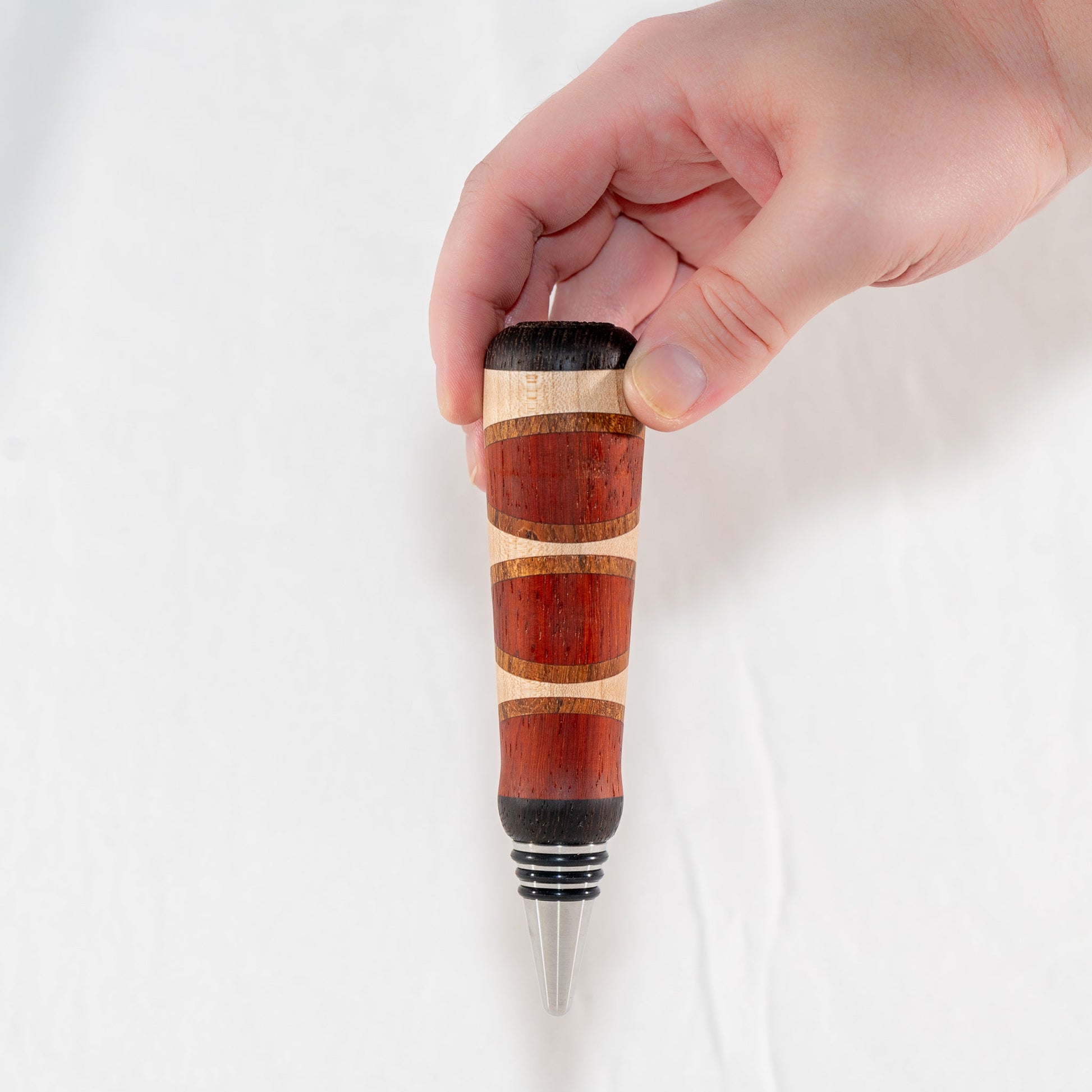Handmade segmented wood bottle stopper of Padauk, Maple, Jatoba, and Wenge woods. Features a stainless steel dropper.