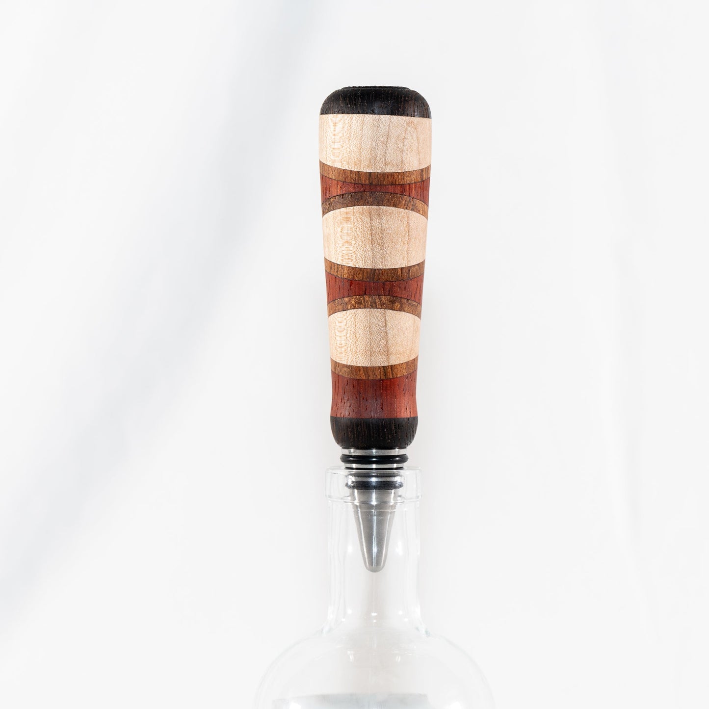 Handmade segmented wood bottle stopper of Padauk, Maple, Jatoba, and Wenge woods. Features a stainless steel dropper.