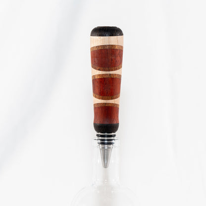 Handmade segmented wood bottle stopper of Padauk, Maple, Jatoba, and Wenge woods. Features a stainless steel dropper.