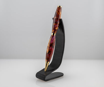 handmade purple, red, and gold ballpoint pen on a black stand