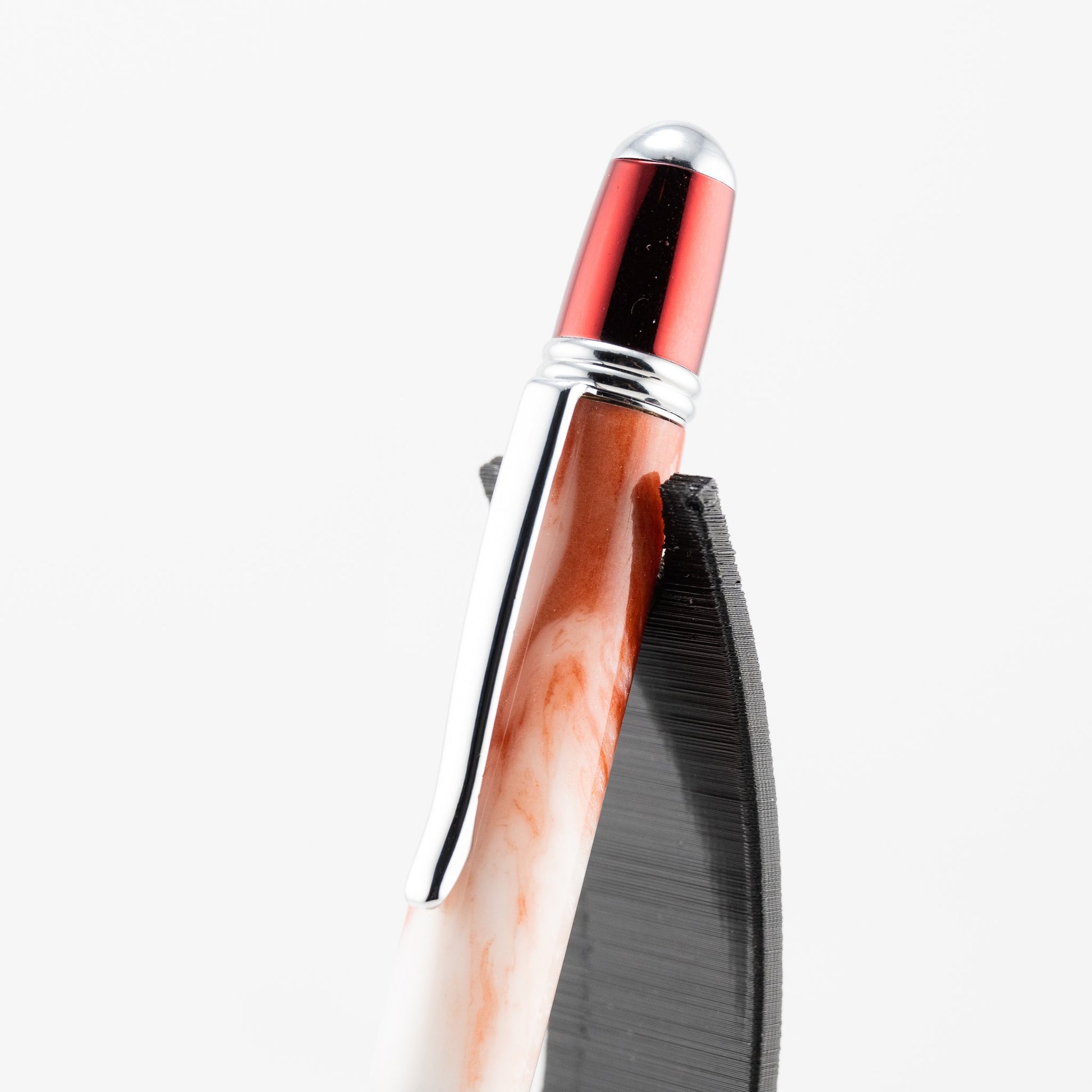 handmade white and red resin ballpoint twist pen with red prism plating on a black stand