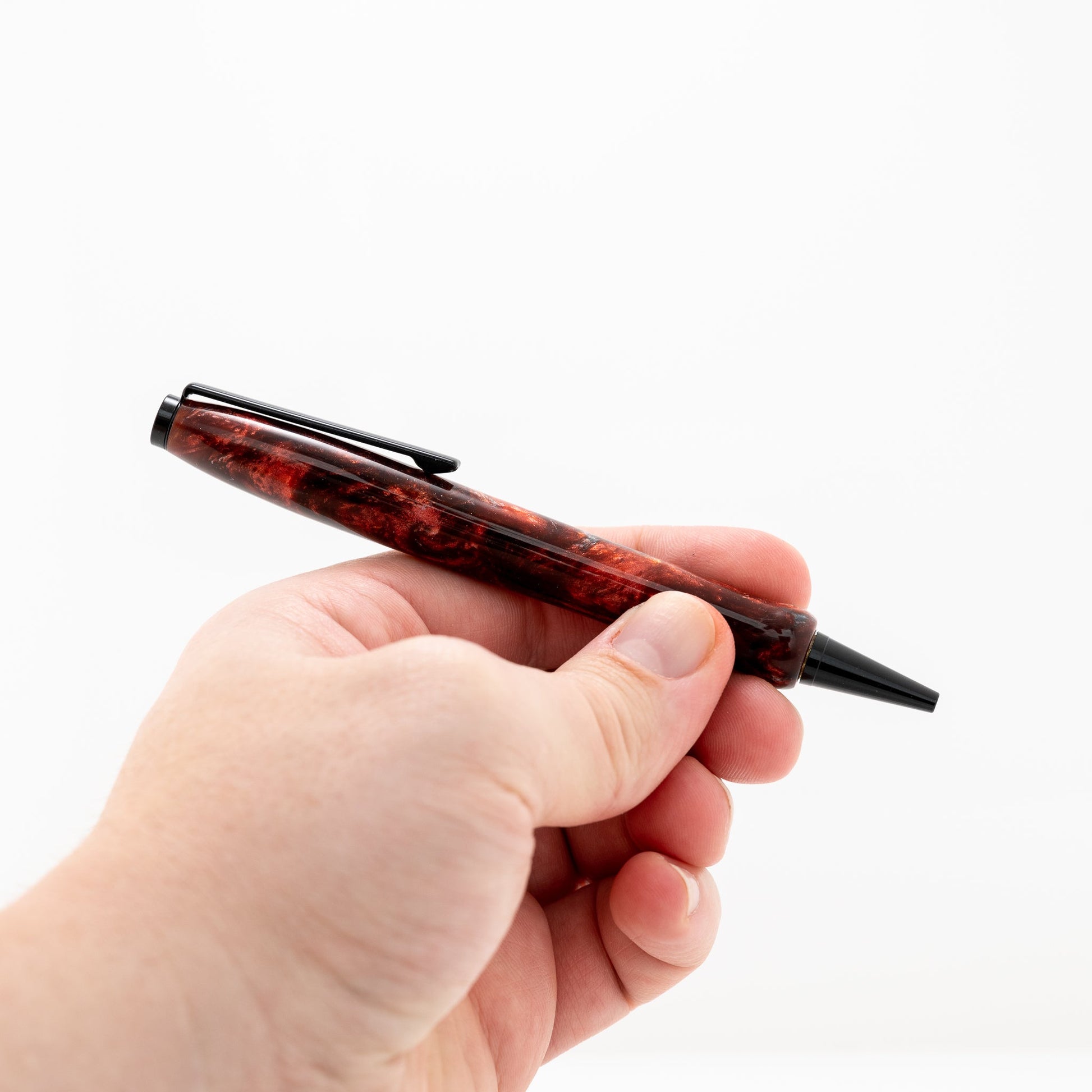 handmade red and purple resin modified slimline twist pen on a black stand