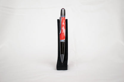 handmade red and white resin ballpoint twist pen with chrome plating on a black stand